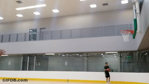 A Man Is Playing Basketball In A Gym With A Hoop In The Background GIF