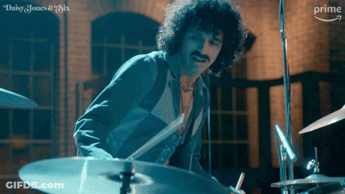 A Man Is Playing Drums In A Daisy Jones And Six Ad GIF