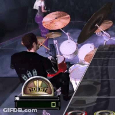 A Man Is Playing Drums In A Video Game With The Word Rock On The Screen GIF