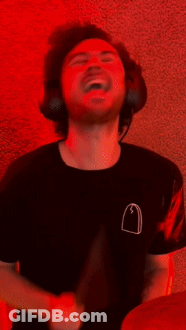 A Man Is Playing Drums In Front Of A Neon Sign That Says ' Music ' GIF