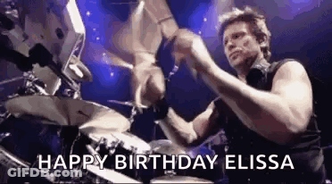 A Man Is Playing Drums On A Stage With The Words `` Happy Birthday Elissa '' Written On It . GIF