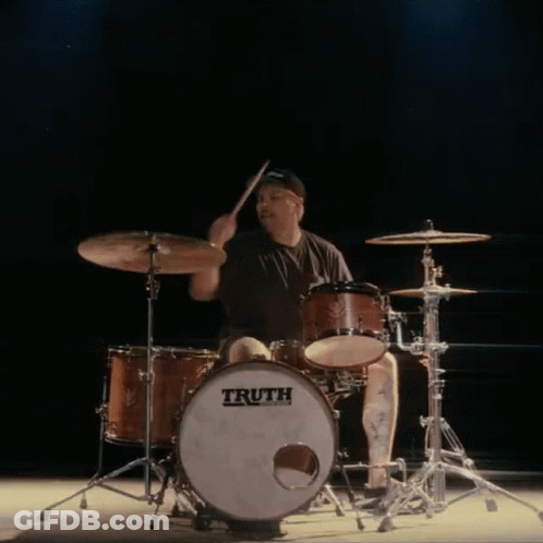 A Man Is Playing Drums With A Truth Drum GIF