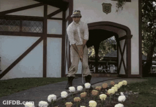 A Man Is Playing Golf In Front Of A Building With A Shield On It That Says ' Eagle ' GIF