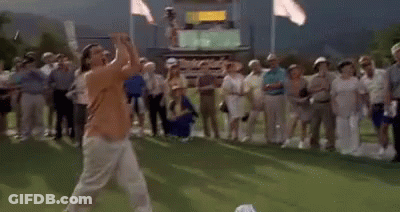A Man Is Playing Golf On A Green While A Crowd Watches . GIF