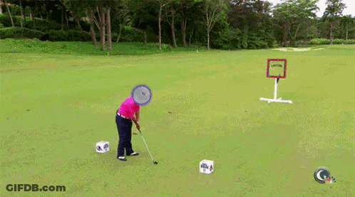 A Man Is Playing Golf On A Lush Green Field With A Sign That Says " Golf " On It GIF