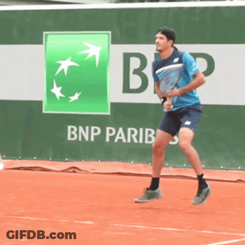 A Man Is Playing Tennis In Front Of A Bnp Pariba Ad GIF