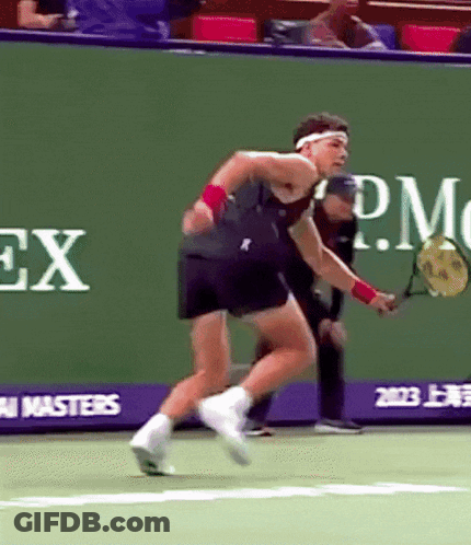 A Man Is Playing Tennis In Front Of A Rolex Advertisement GIF