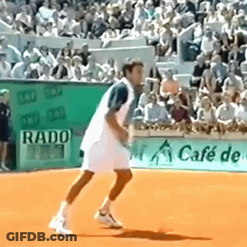 A Man Is Playing Tennis On A Court With A Rado Sign In The Background GIF