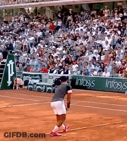 A Man Is Playing Tennis On A Court With A Sign That Says Infosys GIF