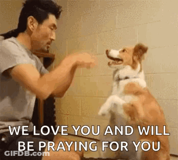 A Man Is Playing With A Dog And Says `` We Love You And Will Be Praying For You '' GIF