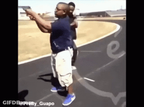 A Man Is Pointing A Gun At Another Man On A Track With The Words Pretty Guapo On The Bottom GIF