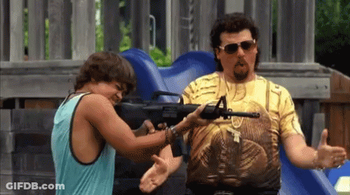A Man Is Pointing A Gun At Another Man While Wearing Sunglasses . GIF