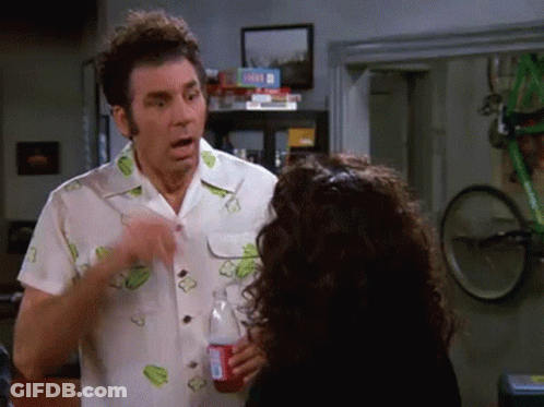 A Man Is Pointing At A Woman Who Is Holding A Coca Cola Bottle . GIF