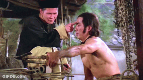 A Man Is Pointing At Another Man 'S Forehead In A Movie Scene GIF
