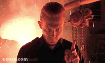A Man Is Pointing At Something In Front Of A Flame GIF