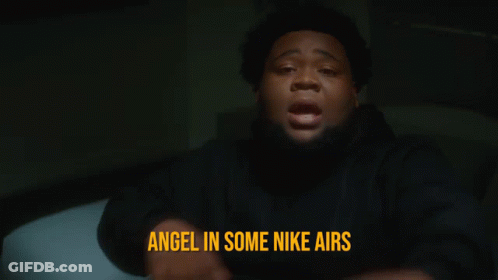 A Man Is Pointing At The Camera With The Words Angel In Some Nike Airs Behind Him GIF