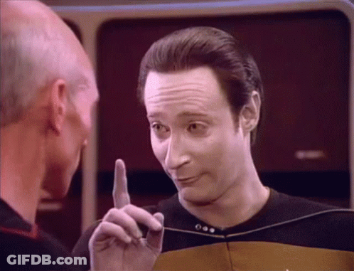 A Man Is Pointing His Finger At Another Man In A Black Shirt GIF