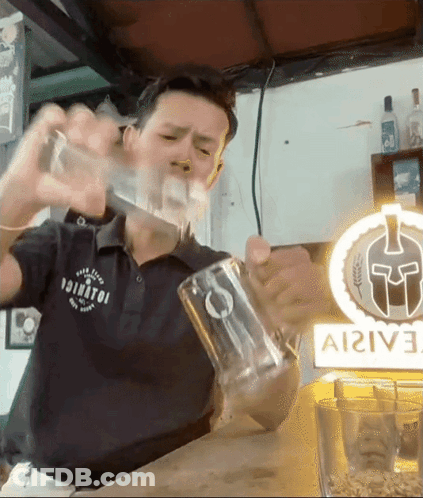 A Man Is Pouring A Drink Into A Glass In Front Of A Sign That Says ' Ai2ive ' On It GIF
