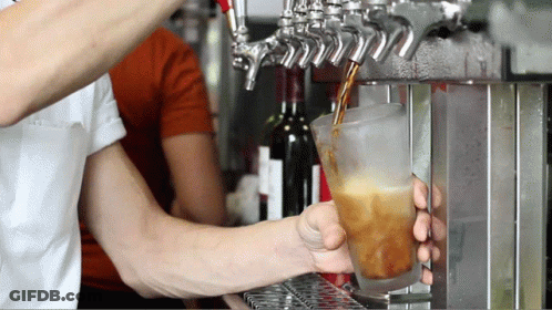 A Man Is Pouring A Drink Into A Glass GIF