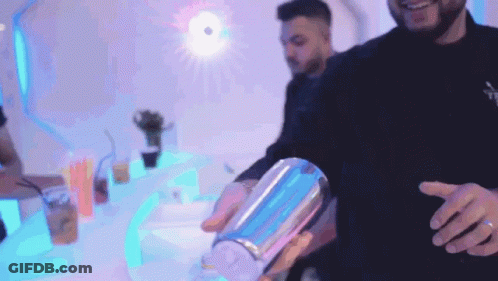A Man Is Pouring A Drink Into A Shaker GIF