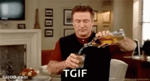 A Man Is Pouring A Glass Of Whiskey From A Bottle In A Living Room . GIF