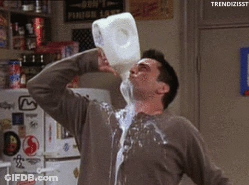 A Man Is Pouring Milk Into His Mouth From A Gallon GIF