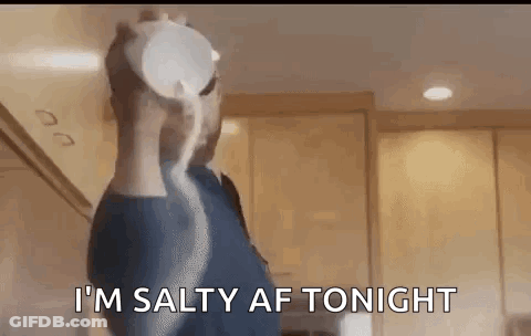 A Man Is Pouring Salt Into A Bowl In A Kitchen . GIF