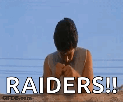 A Man Is Praying For The Raiders While Standing On A Roof . GIF