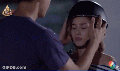 A Man Is Putting A Helmet On A Woman 'S Head With A Hd Logo In The Background GIF