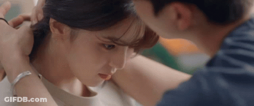 A Man Is Putting A Ring On A Woman 'S Ear . GIF