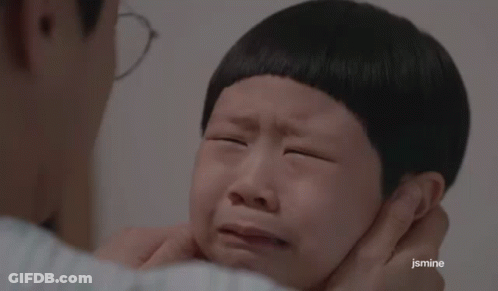 A Man Is Putting His Hand On A Child 'S Face Who Is Crying . GIF