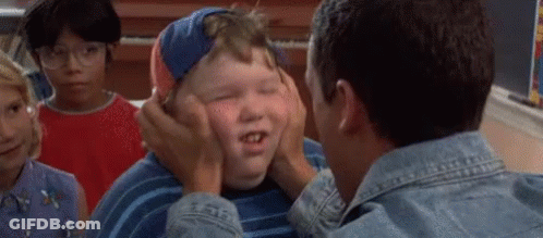 A Man Is Putting His Hands On A Boy 'S Face . GIF