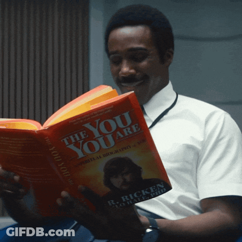 A Man Is Reading A Book Called The You Are By R. Ricken GIF