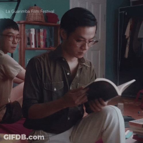 A Man Is Reading A Book With La Guarimba Film Festival Written On The Bottom GIF