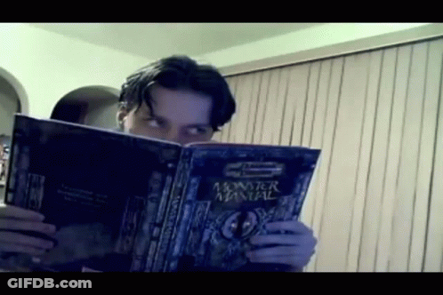 A Man Is Reading A Monster Manual GIF