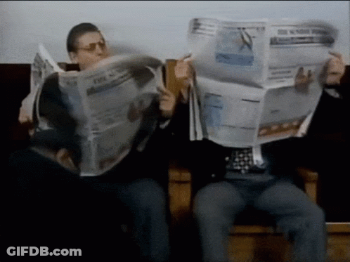 A Man Is Reading A Newspaper That Says The New York Times GIF