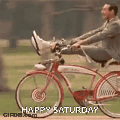 A Man Is Riding A Bicycle With His Feet Up And The Words `` Happy Saturday '' . GIF