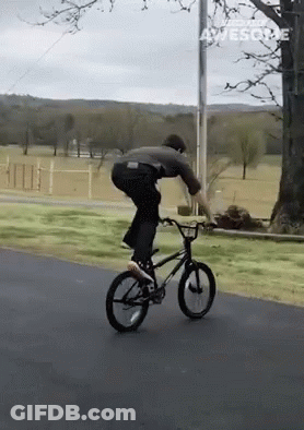 A Man Is Riding A Bike Down A Road And The Words Awesome Are On The Bottom Right GIF