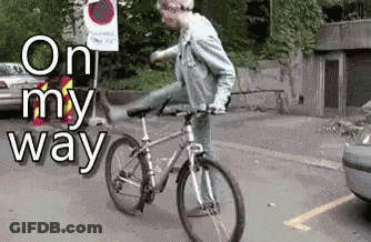 A Man Is Riding A Bike In A Parking Lot With The Words On My Way Behind Him GIF