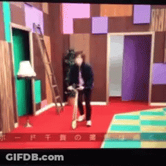 A Man Is Riding A Bike In A Room With Chinese Characters On The Bottom GIF