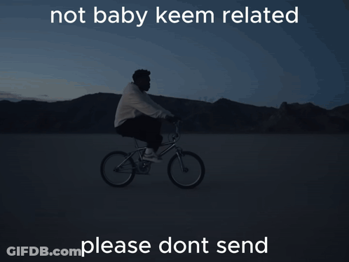 A Man Is Riding A Bike In The Dark With The Words Not Baby Keem Related Below Him GIF