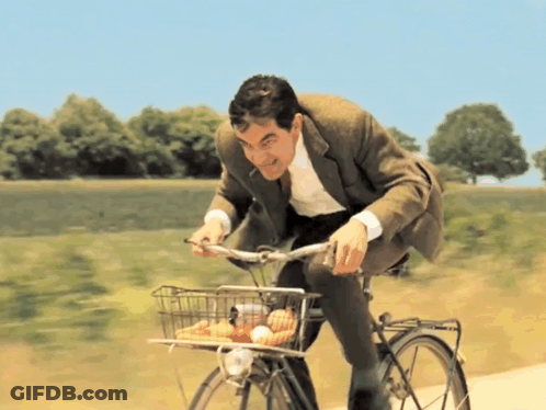 A Man Is Riding A Bike With A Basket Full Of Food GIF
