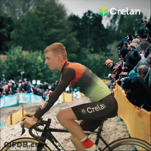 A Man Is Riding A Bike With Crelan On His Shorts GIF