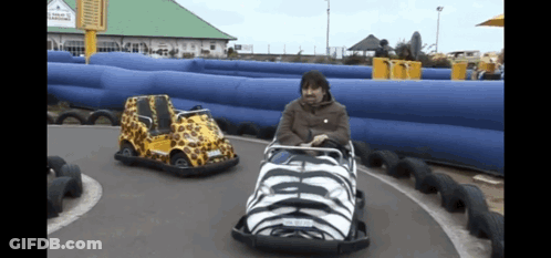 A Man Is Riding A Go Kart With A License Plate That Says ' Aa ' On It GIF