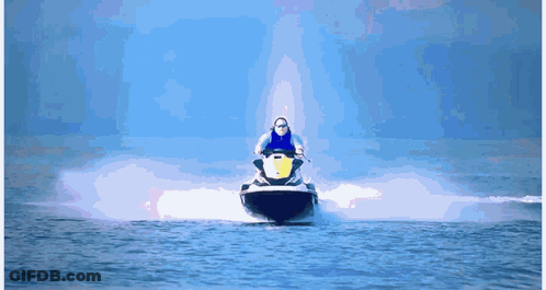 A Man Is Riding A Jet Ski In The Water GIF