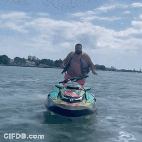 A Man Is Riding A Jet Ski On The Water GIF