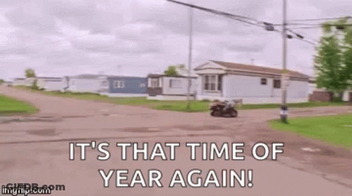 A Man Is Riding A Motorcycle Down A Dirt Road With The Words `` It 'S That Time Of Year Again '' . GIF