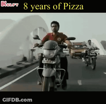 A Man Is Riding A Motorcycle On A Highway With The Words 8 Years Of Pizza Above Him GIF