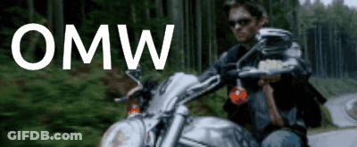 A Man Is Riding A Motorcycle On A Road With The Word Omw Written Above Him GIF