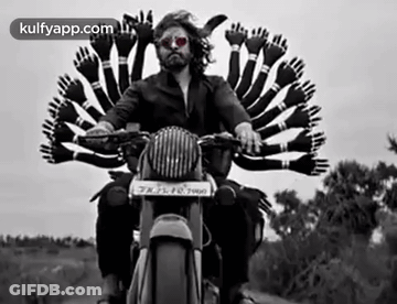 A Man Is Riding A Motorcycle With A Bunch Of Hands On The Back . GIF